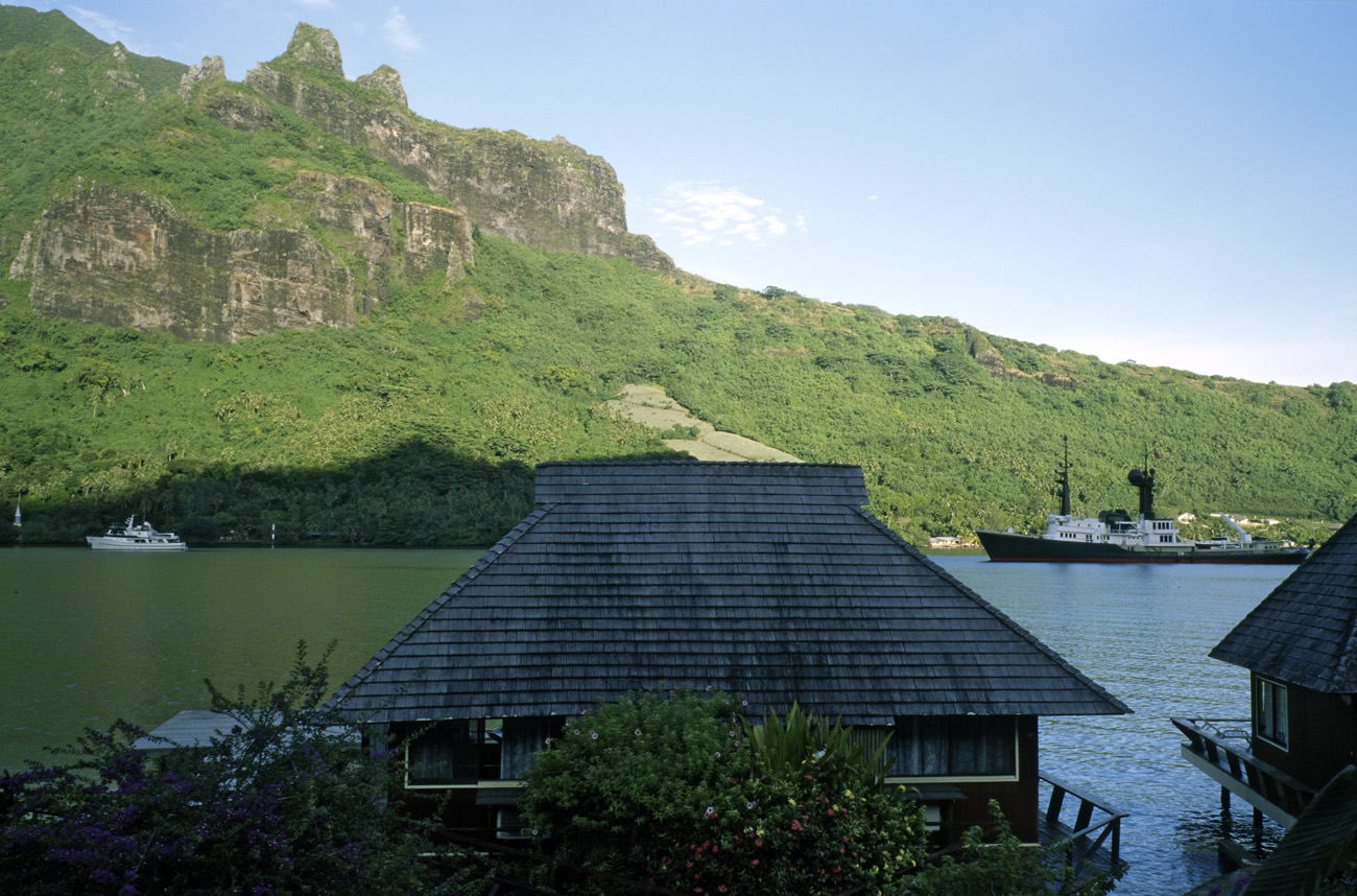 pol05_0854l.jpg - Iles de la Société, Moorea baie de Cook, au lever du soleil : eau verte dans la partie restée dans l'ombre, bleue côté soleil